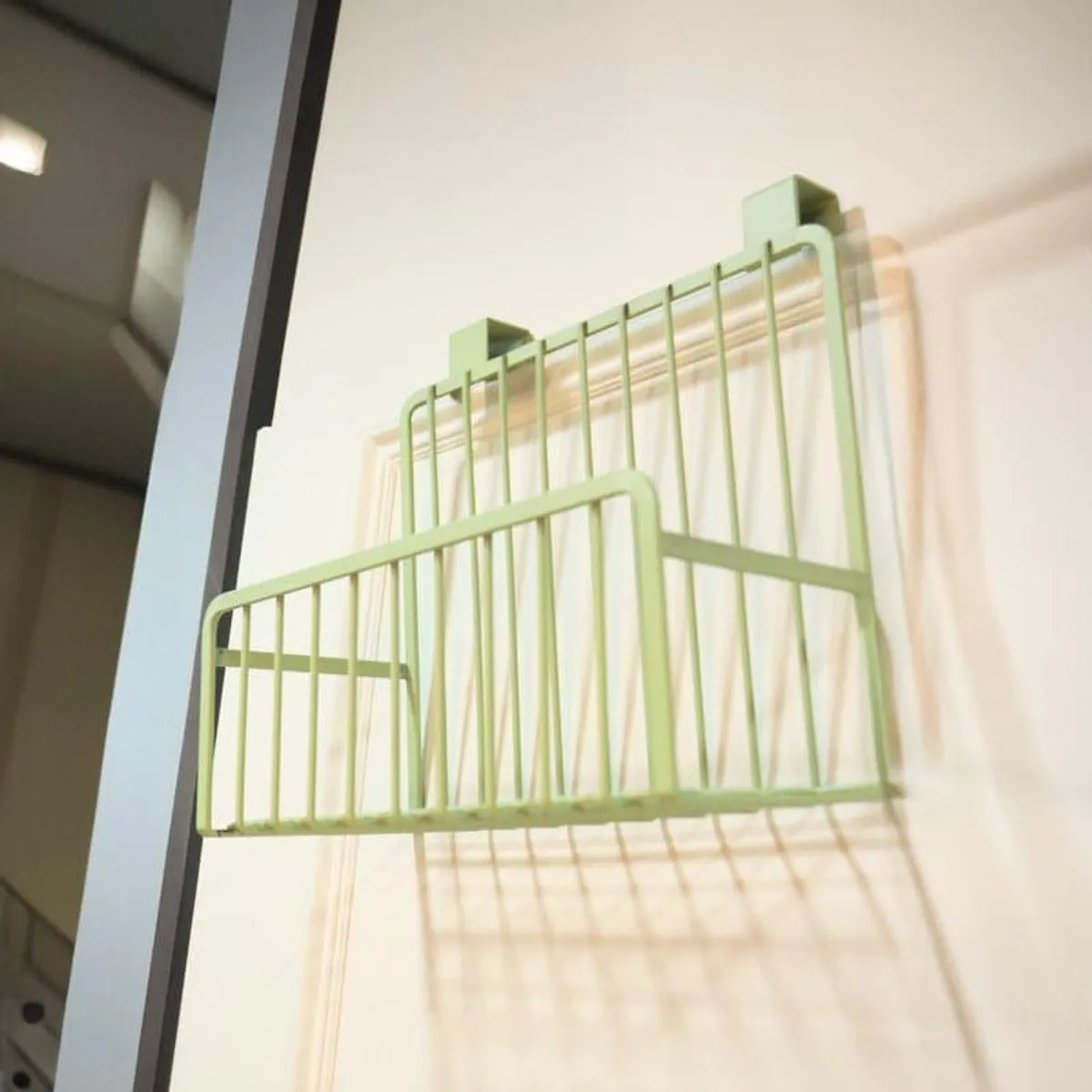 Angled view of a green metal over-the-door rack shelf