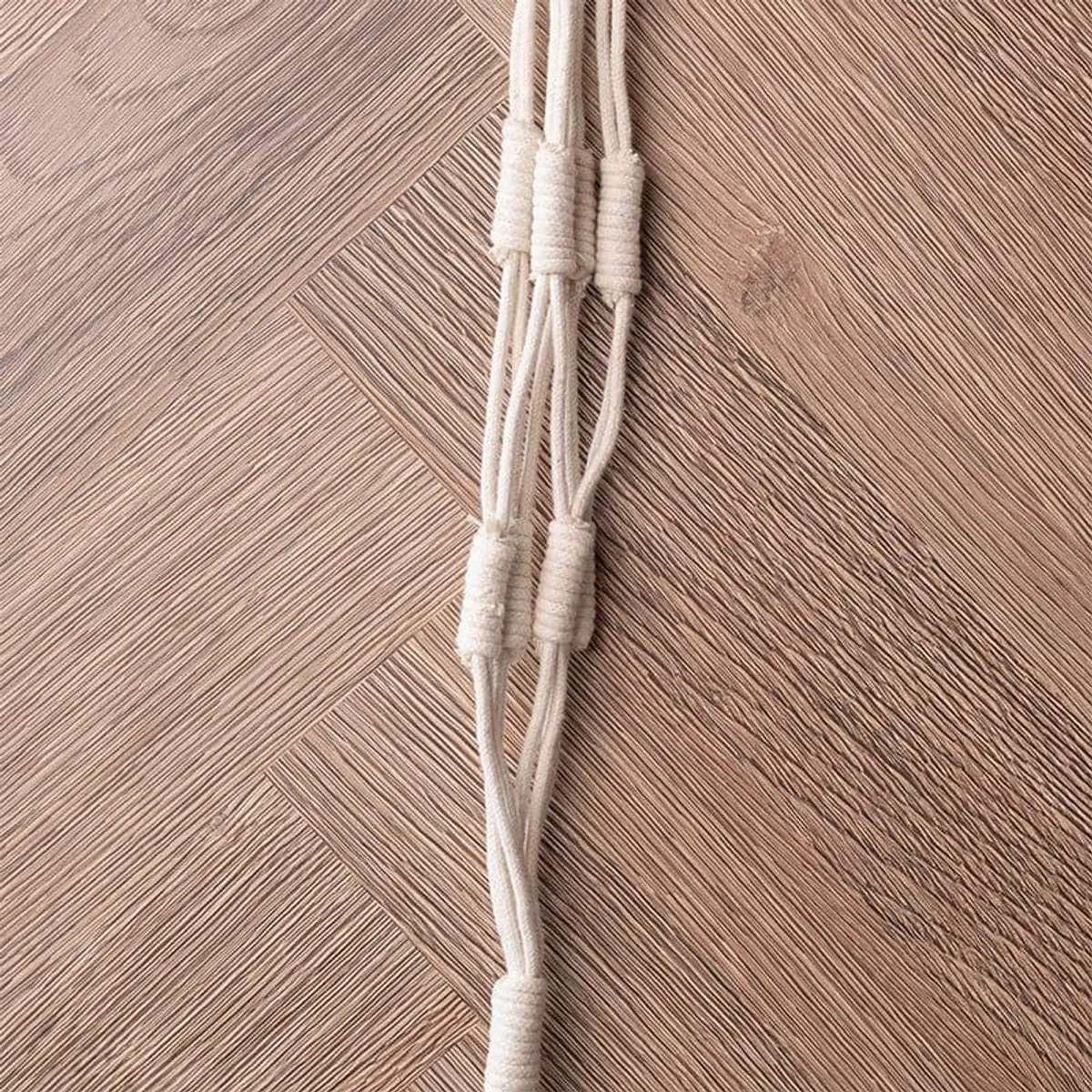 Close-up of the white planter's braided ropes and knotted macrame detail