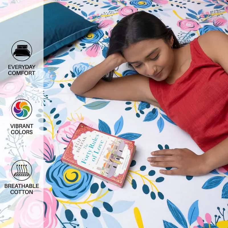 Person reclining on floral cotton bedsheet with blue pillow cover nearby