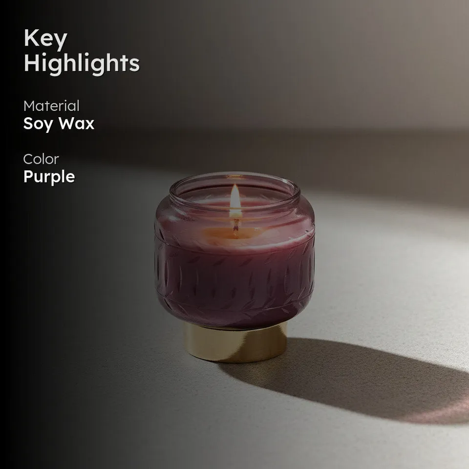 Purple candle in embossed glass jar with gold-toned base