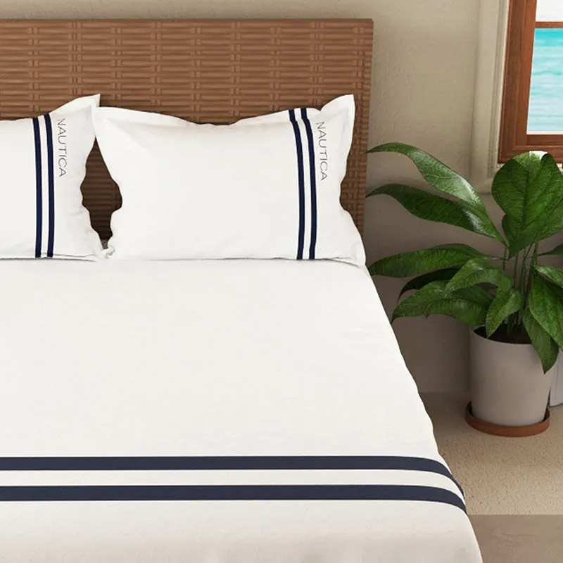 Close view of white bedding with parallel navy stripes across the lower edge.