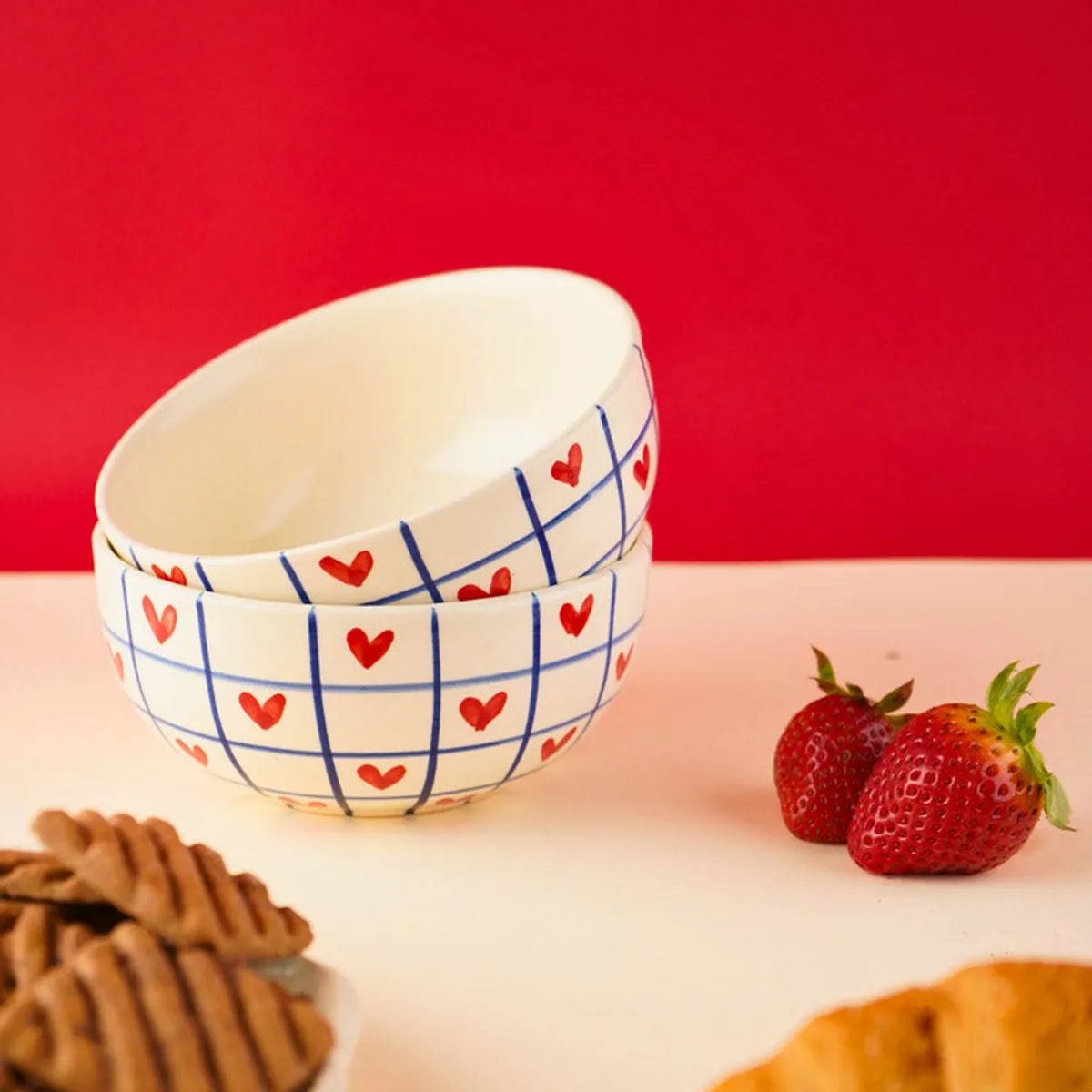 Two heart grid bowls styled with strawberries and pastries