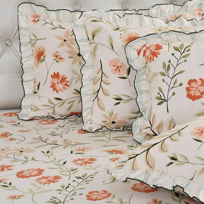 Close-up of frilled pillow covers and floral bedsheet