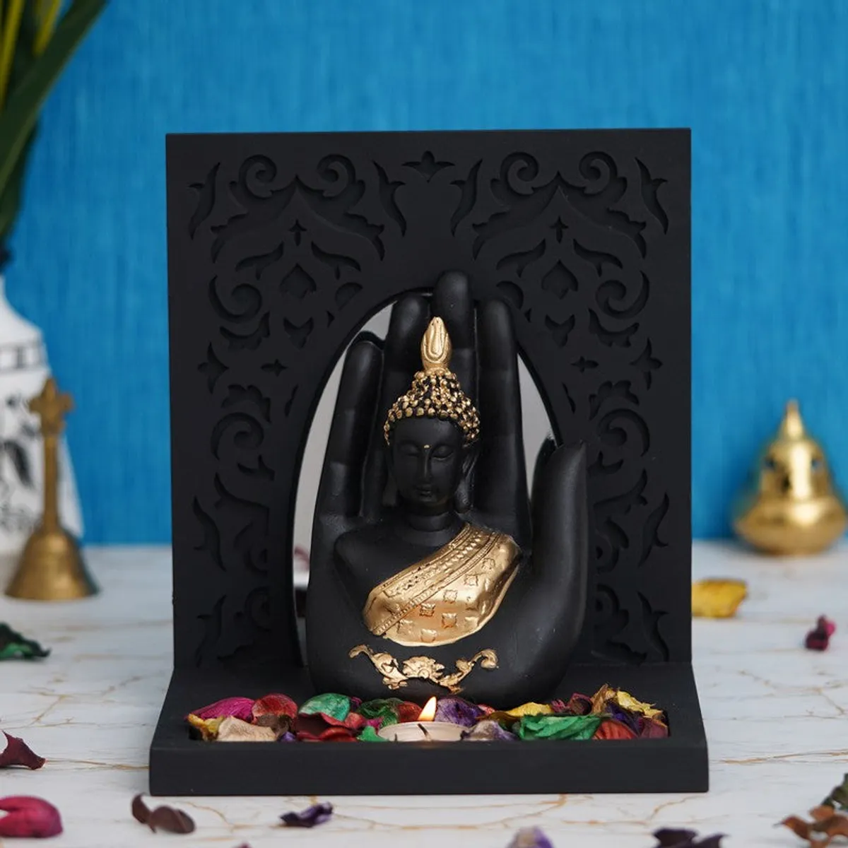 Black and gold Buddha candle holder styled on a tabletop