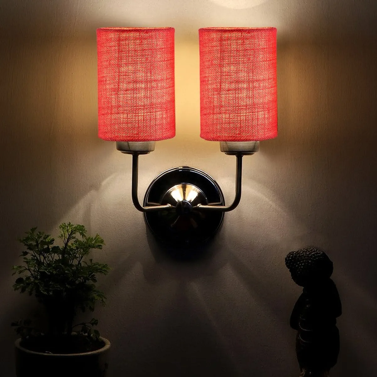 Lit red jute wall lamp casting light upward