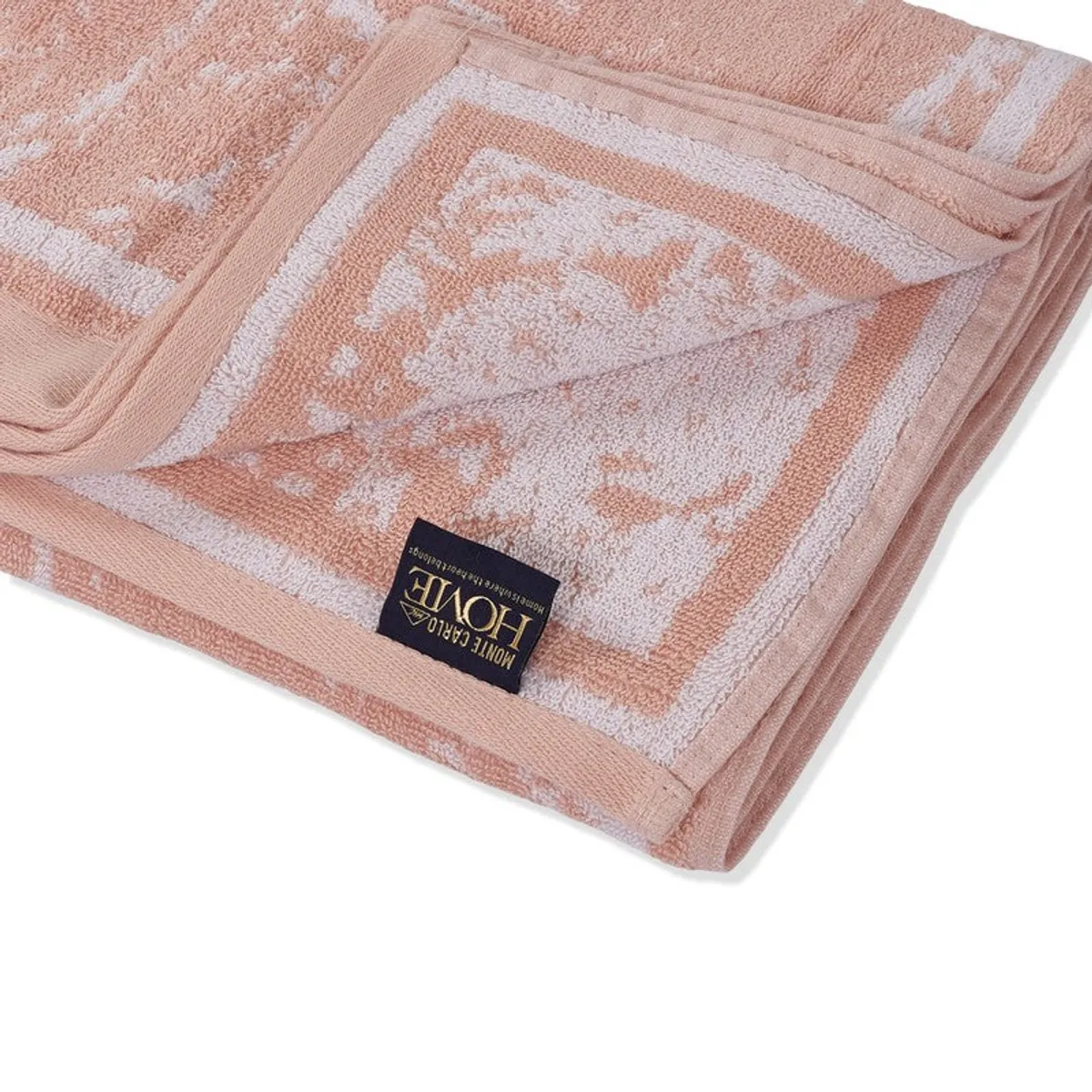 Close-up of the peach towel's soft patterned surface, border and label