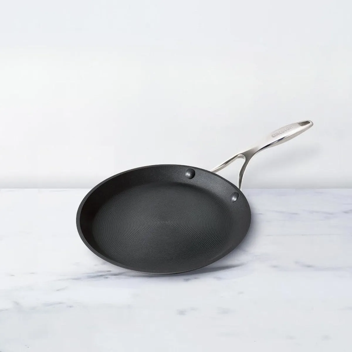 Black round dosa tawa displayed alone against a light background