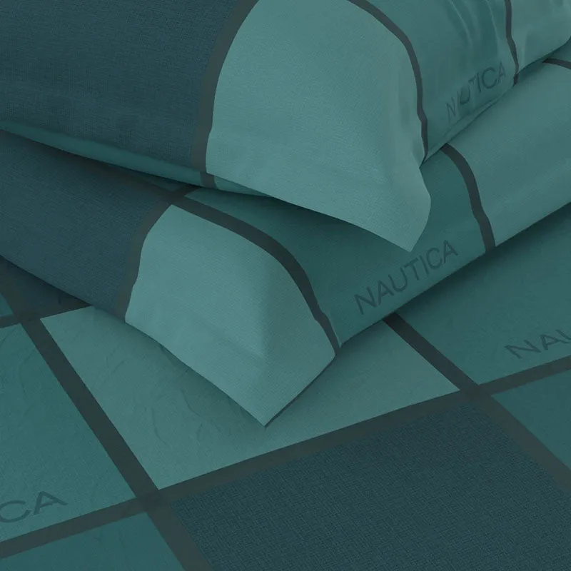 Close-up of the bedsheet's teal cotton texture and checked print