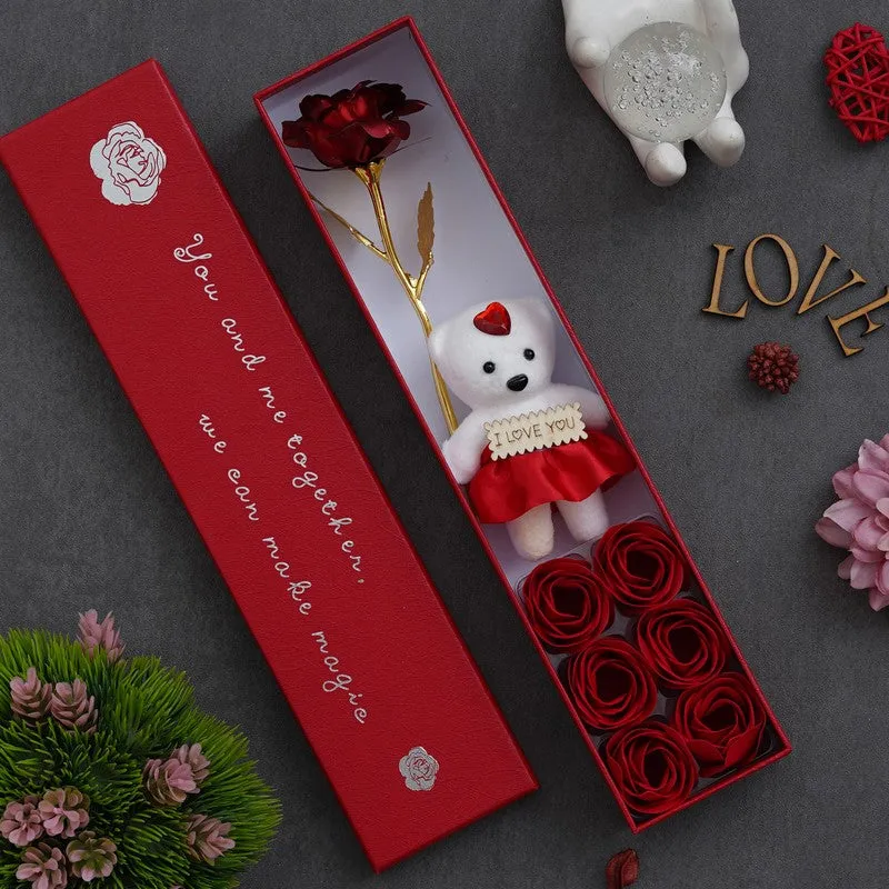 Open red gift box showing teddy, rose and red rose accents inside