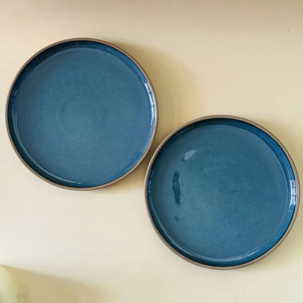 Two blue quarter plates viewed from above on a light surface