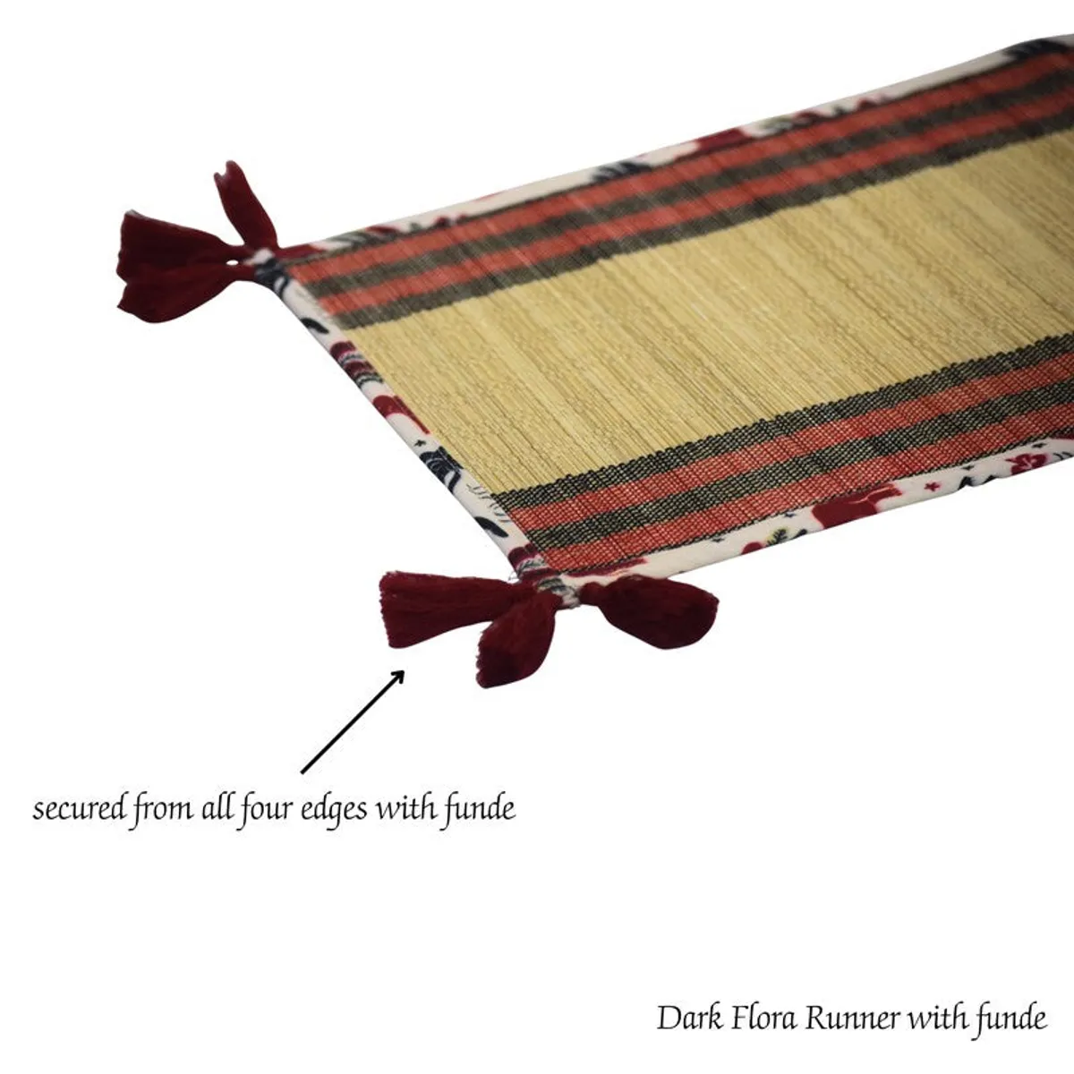 Close-up of beige and red bamboo runner corner finished with red tassels
