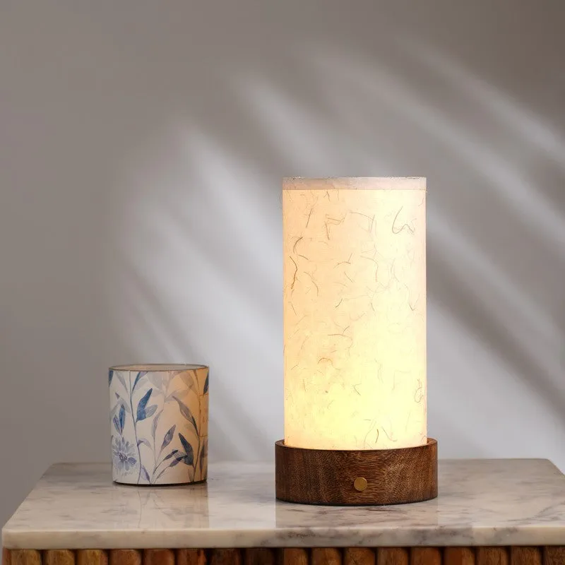 Glowing ivory table lamp with wooden base styled on a marble surface