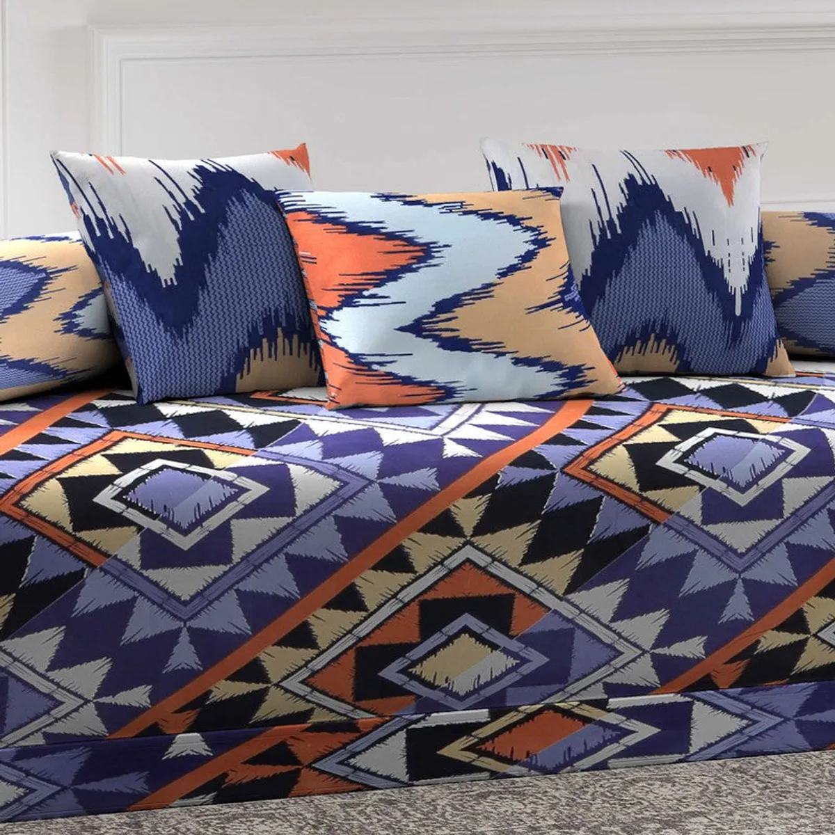 Close-up of cushion covers and geometric printed diwan bedsheet