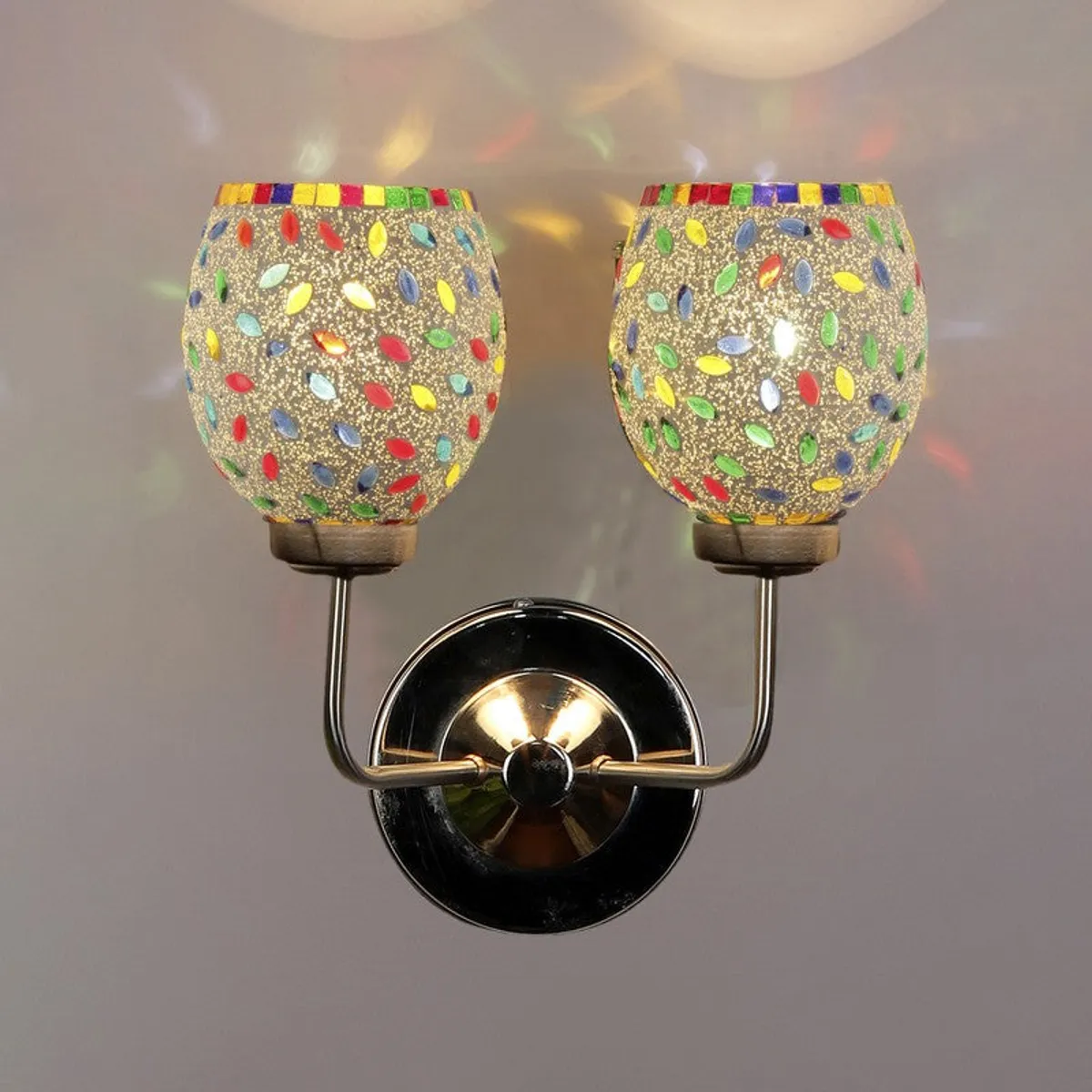 Front view of dual mosaic glass wall lamp against a plain wall