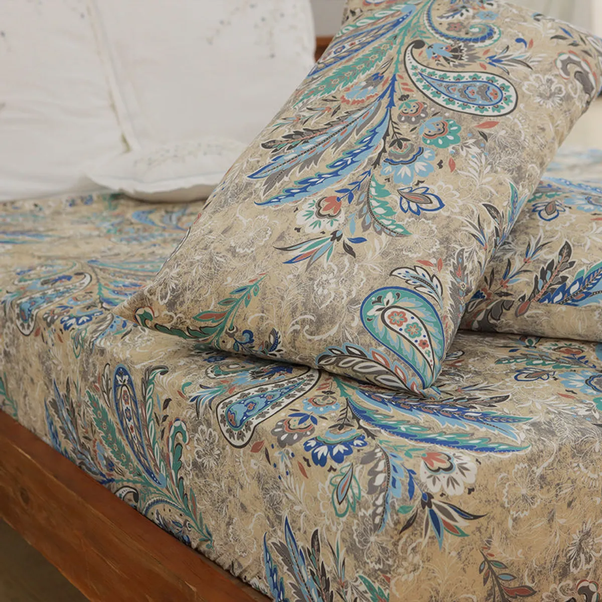 Printed blue and beige duvet cover styled with pillows on a bed