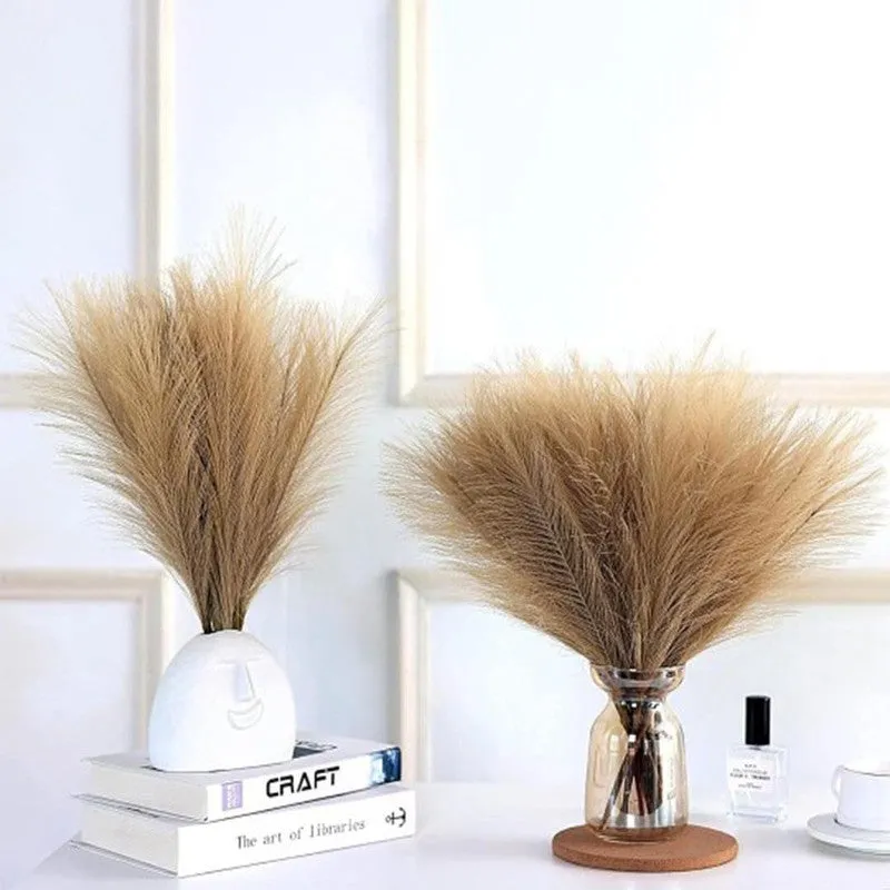 Brown pampas arrangements styled in two vases on a white console
