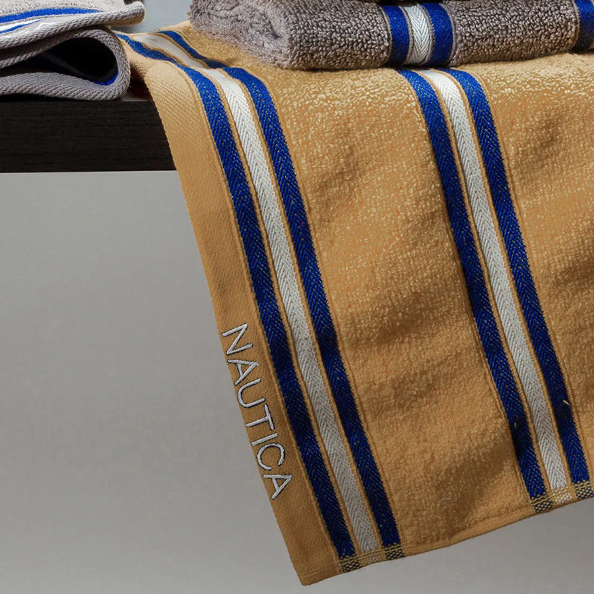 Close-up of yellow striped towel with Nautica branding