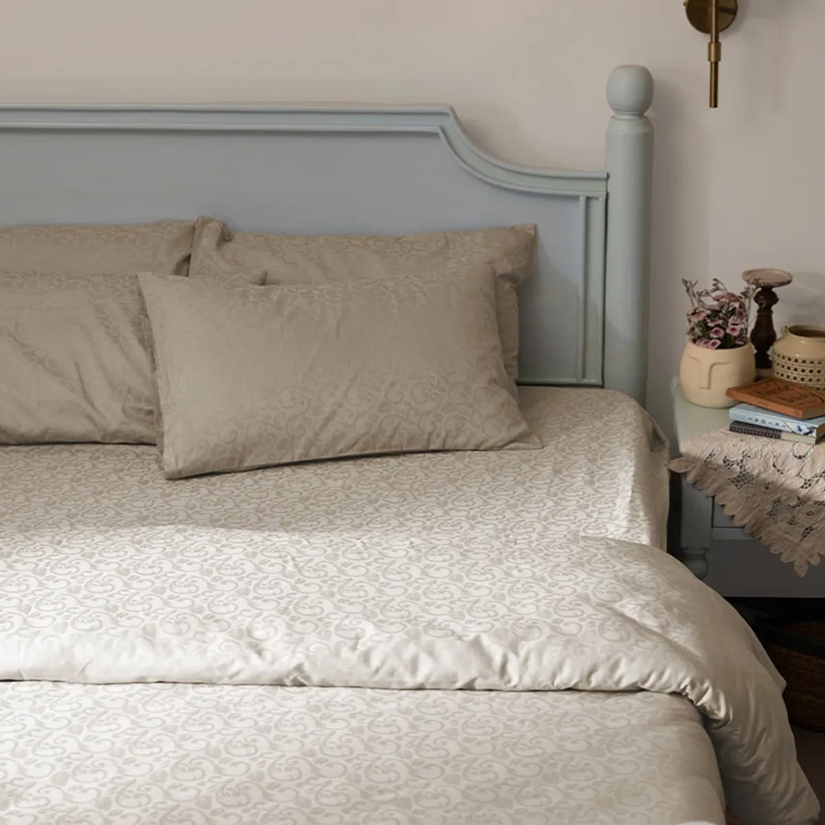 Beige floral jacquard bedsheet styled on a bed with matching pillows