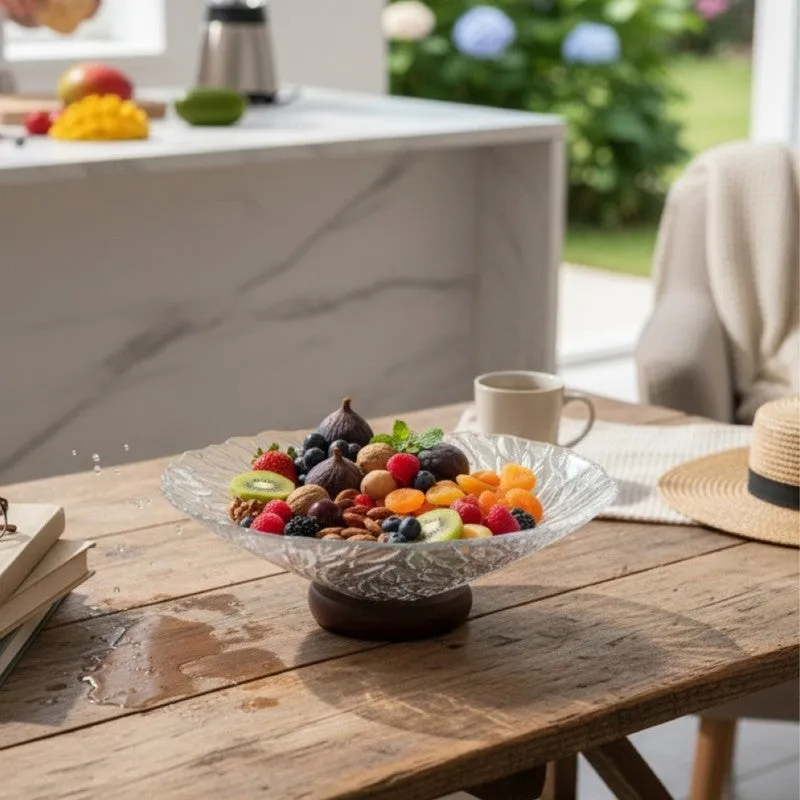 Transparent glass fruit bowl filled with colourful fruit on a wooden dining table