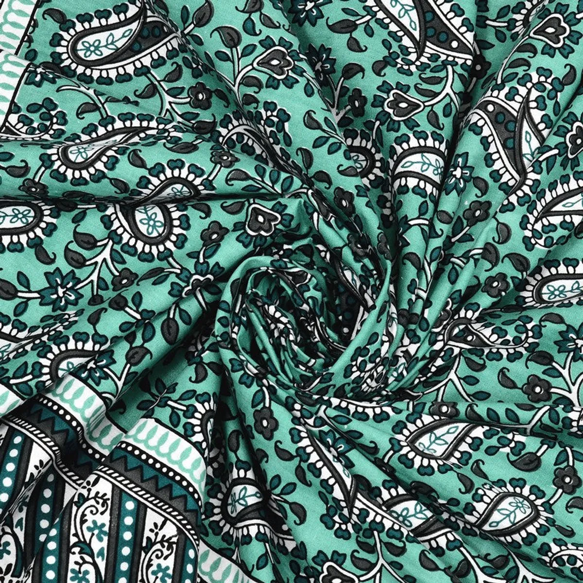 Close-up of softly folded green cotton fabric with floral paisley print