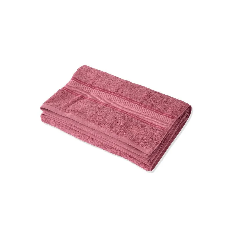 Folded pink bath towel on a white background