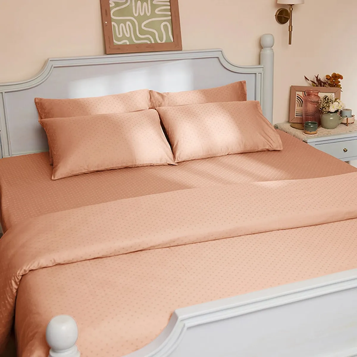 Peach dotted duvet cover styled on a bed with matching pillows in a classic bedroom