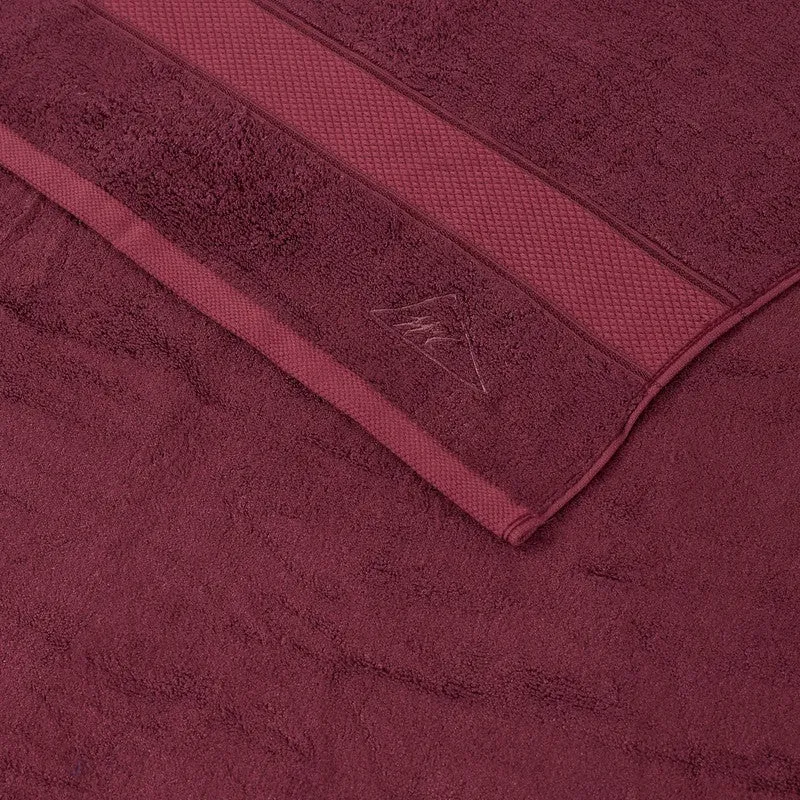 Close-up of maroon bath towel with woven border and soft pile