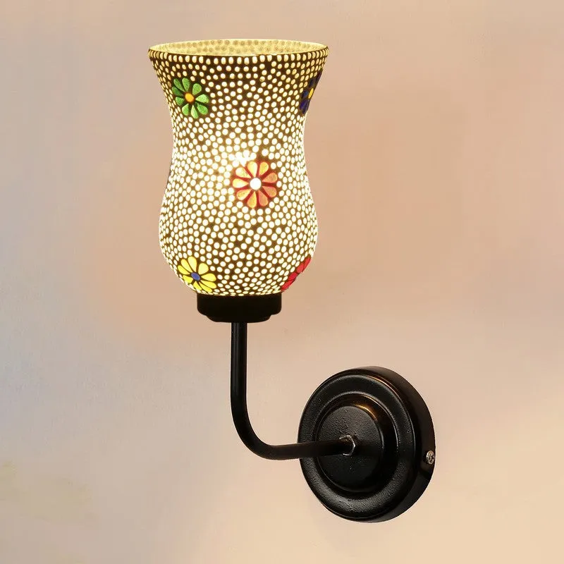 Front view of illuminated white mosaic glass wall lamp on black iron base