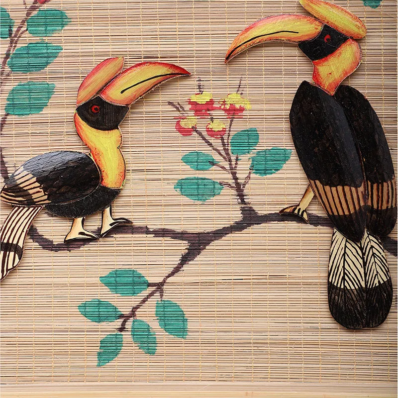 Close-up of toucan bamboo wall art showing layered birds, branches and teal leaves.