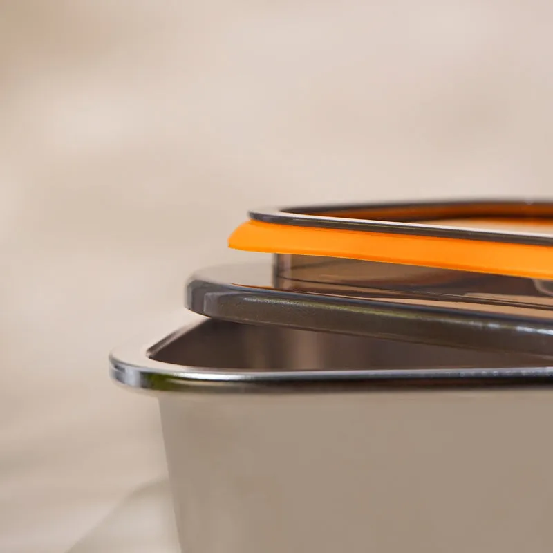 Close-up of the dark lid, orange seal and stainless steel container rim