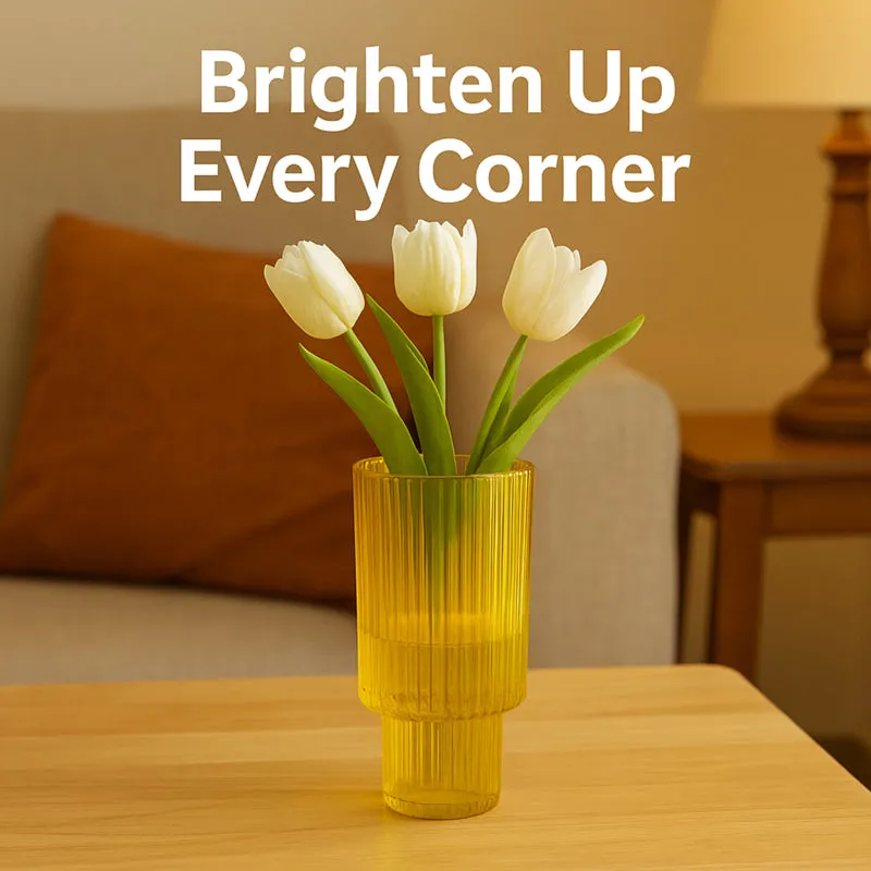 Yellow ribbed glass vase with white tulips on a light wood table