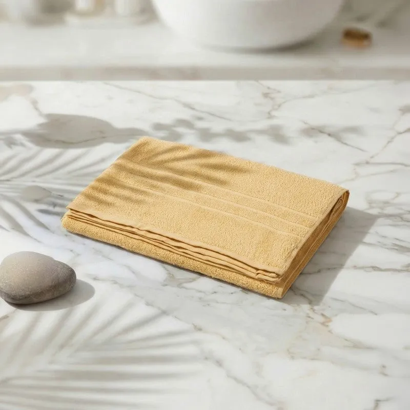 Folded yellow bath towel displayed on a marble surface