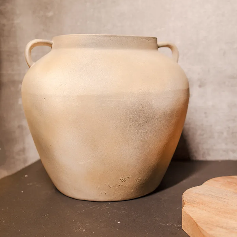 Front view of a beige ceramic vase with side handles