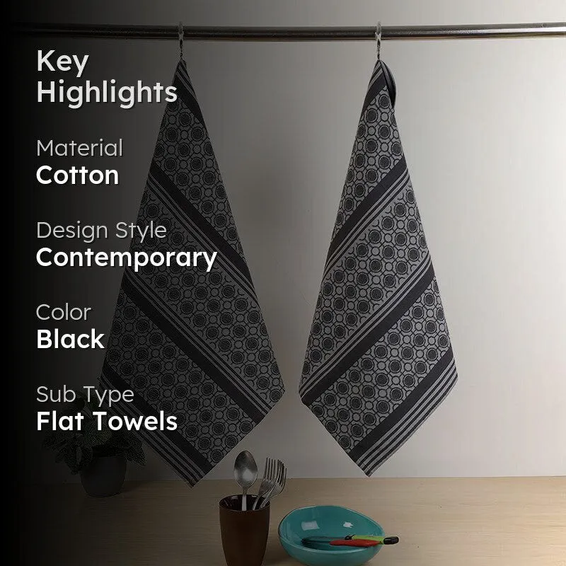 Two patterned black and grey kitchen towels hanging side by side