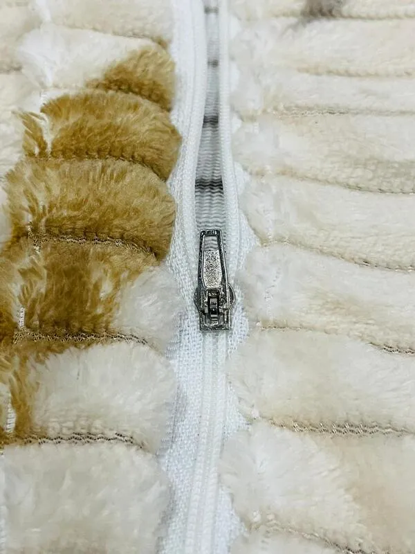 Close-up of white zip detail on ribbed flannel fabric