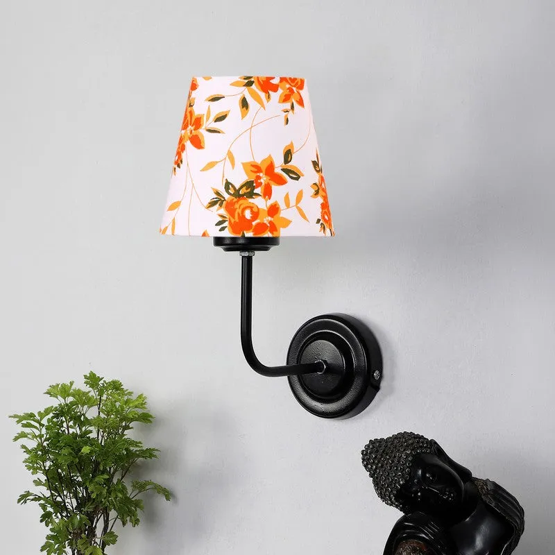 Black wall lamp with white floral cone shade in orange tones