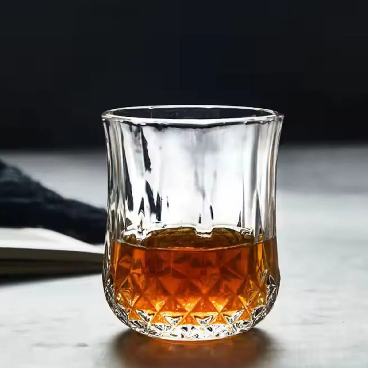 Clear crystal-cut whisky glass filled with an amber drink