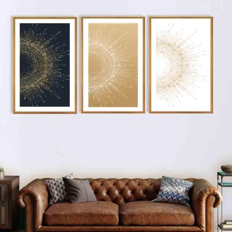 Set of three starburst wall art pieces displayed above a brown sofa