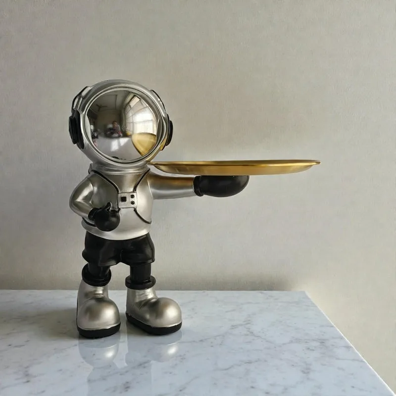 Front view of a silver astronaut figurine with a gold tray