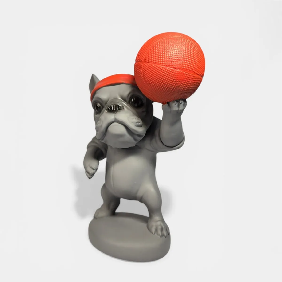 Angled front view of the bulldog showpiece holding an orange ball