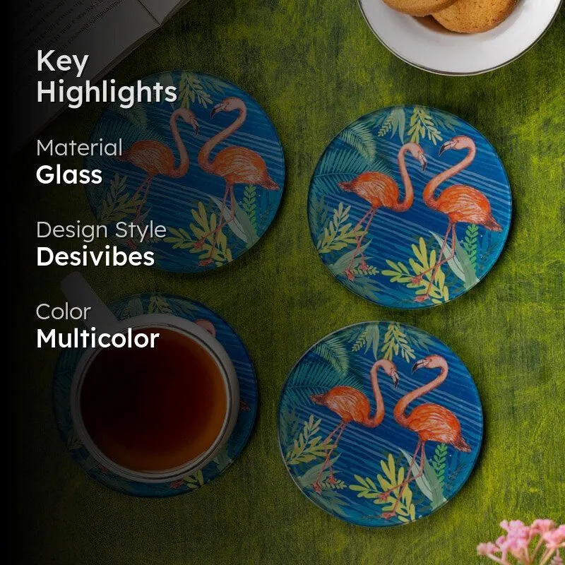 Four blue flamingo coasters shown on a green table beside tea and biscuits