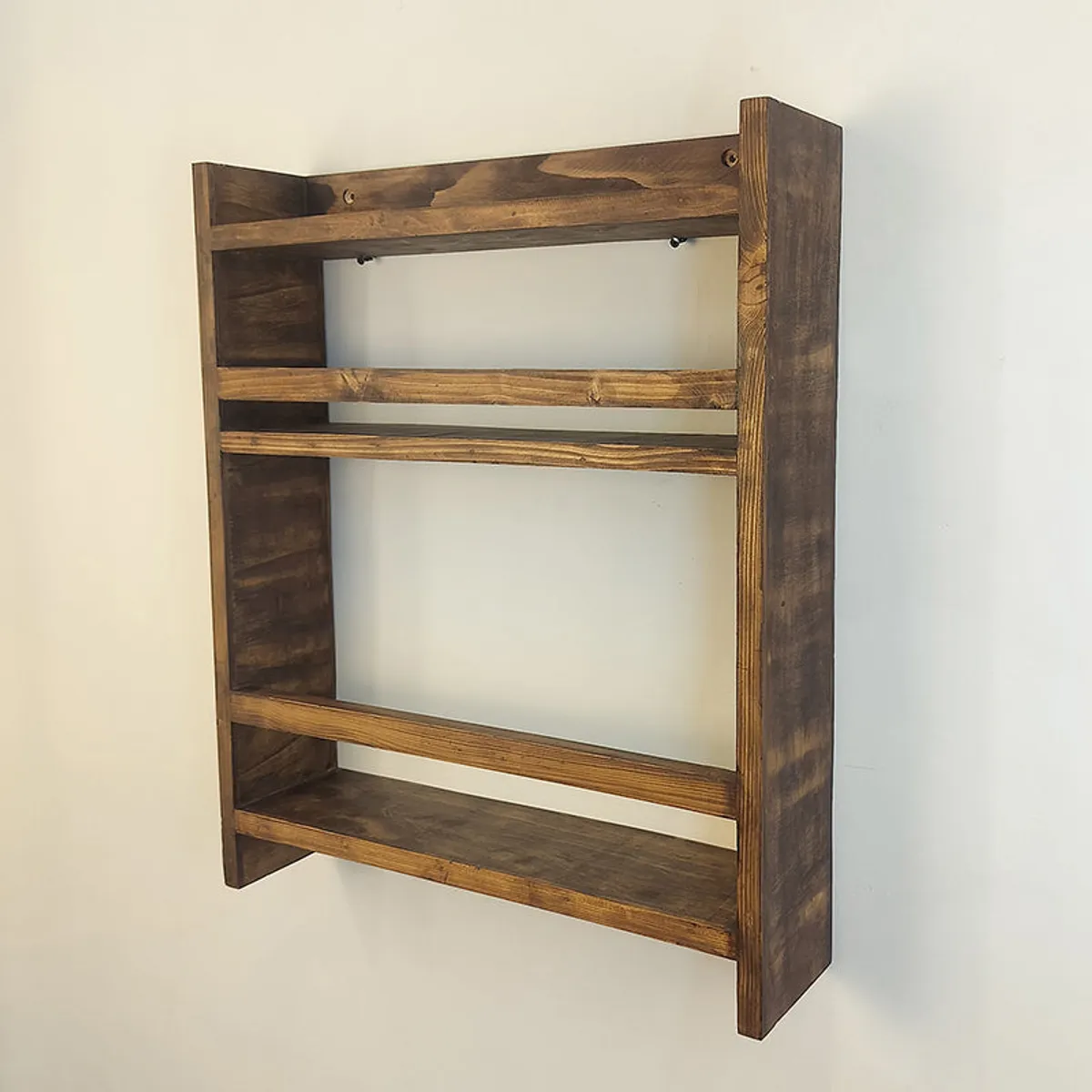 Side view of the empty brown wooden rack showing its shelves and deep frame
