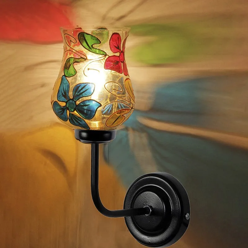 Close view of floral mosaic glass wall lamp with black iron wall mount