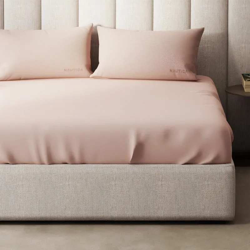 Pink satin-finish bedsheet and pillow covers shown on a neutral upholstered bed