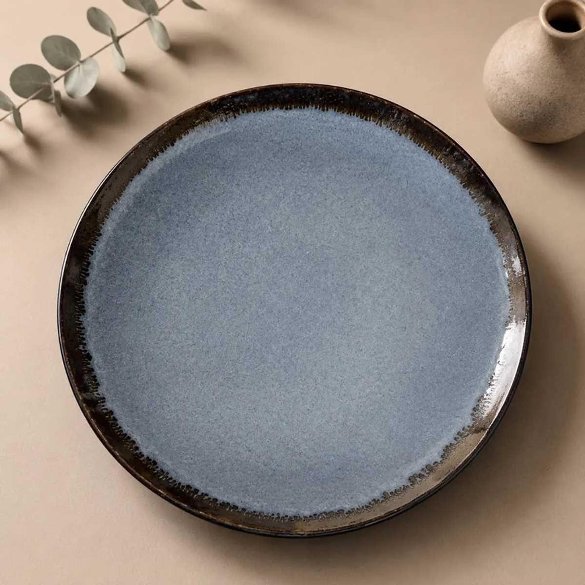 Close-up of a deep blue glossy ceramic plate with a dark rim