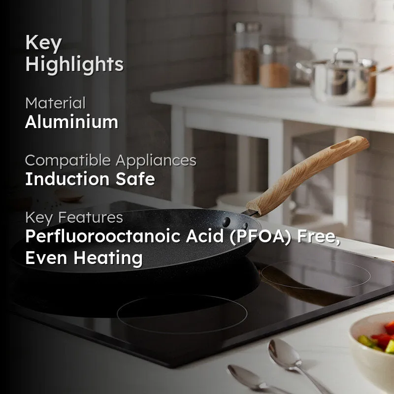 Black dosa tawa in a kitchen scene with its light wooden-finish handle visible