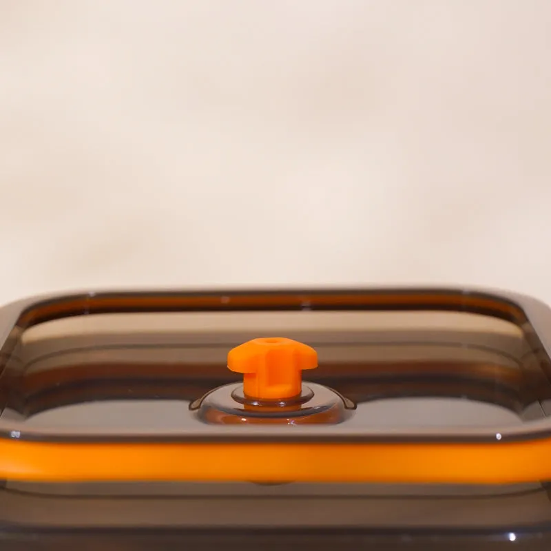 Close-up of the dark translucent lid with orange centre knob