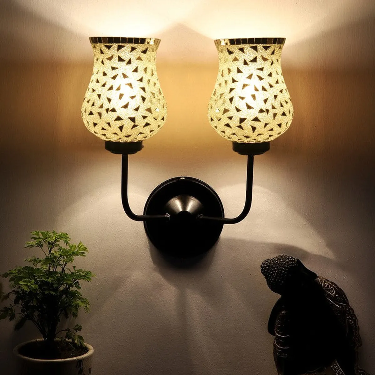 Front view of lit twin mosaic glass wall lamp casting an upward glow