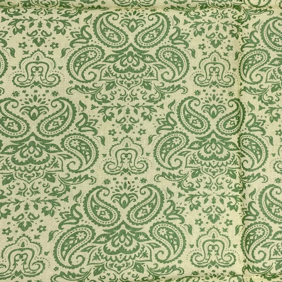 Close-up of green paisley pattern on cream fabric
