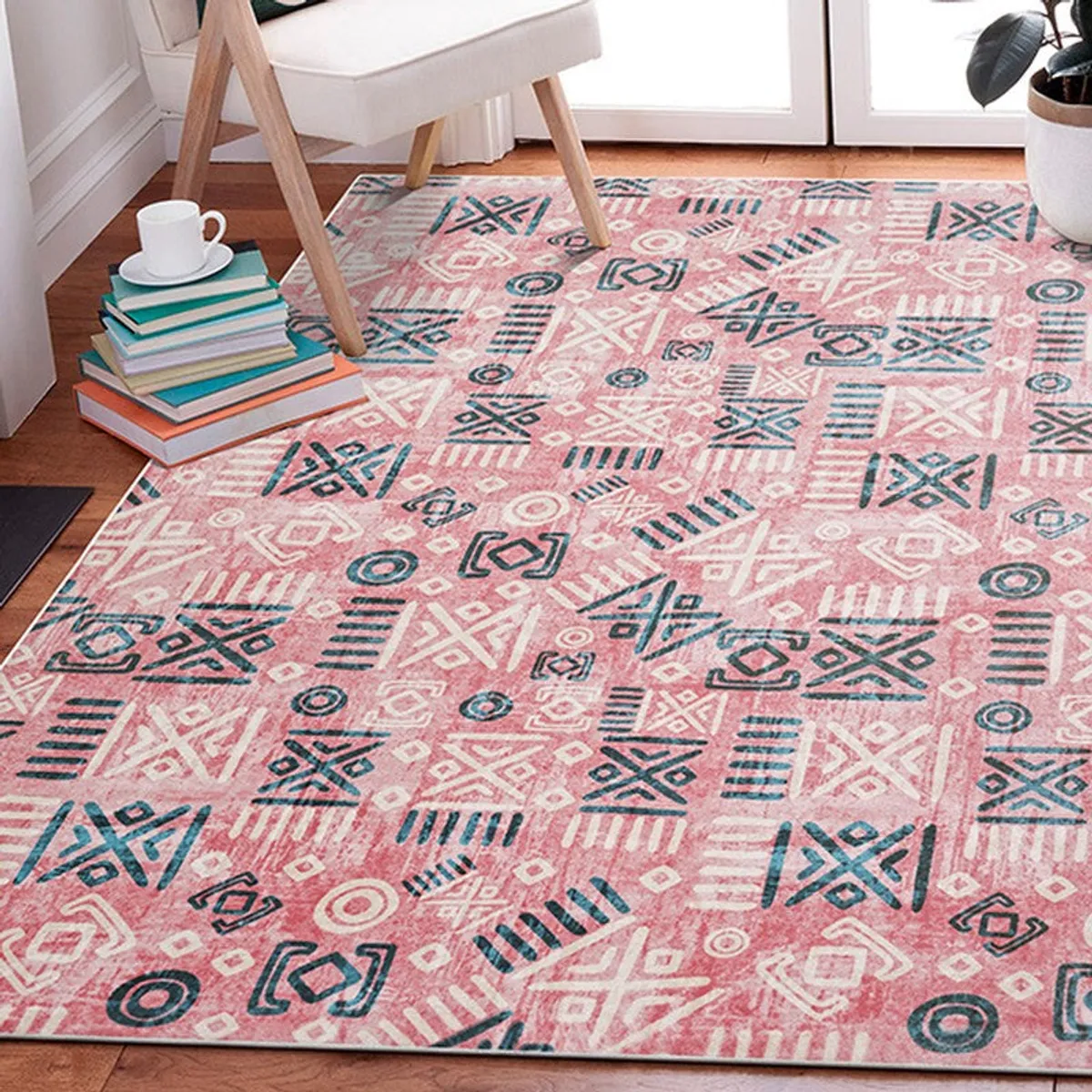 Pink abstract carpet placed beside a chair in a room
